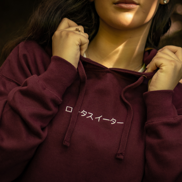 Lotus Eater Model Wearing Burgundy Hoodie Outerwear. Brand Logo Embroidery and Relax Back Design.