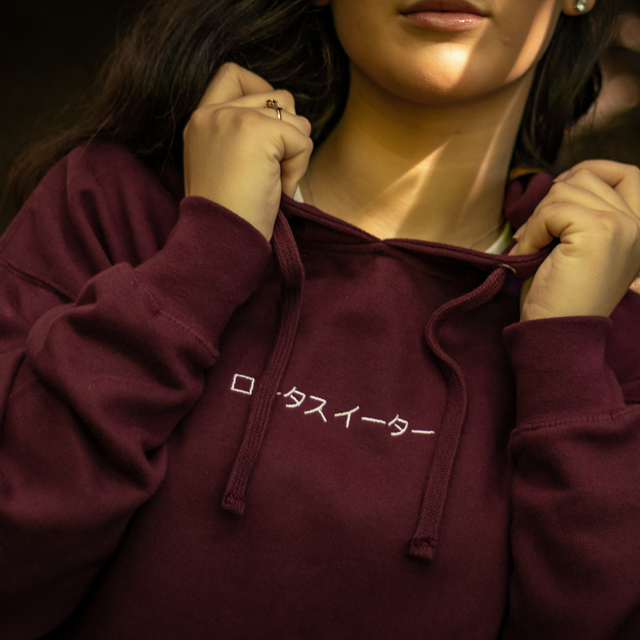 Lotus Eater Model Wearing Burgundy Hoodie Outerwear. Brand Logo Embroidery and Relax Back Design. 